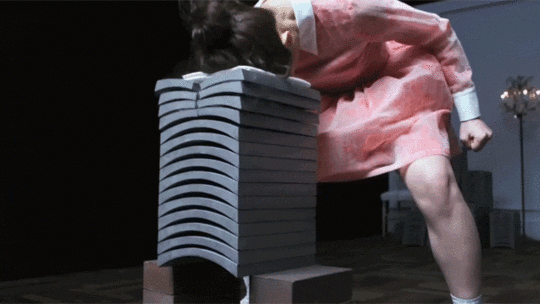 Fashionable Young Woman Breaks Roof Tiles with Her Head