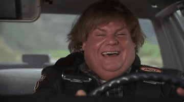 Chris Farley driving along all happy, but gets scared as he realizes something.