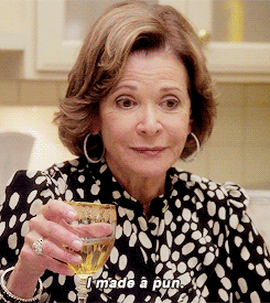 Lucille Bluth from Arrested Development, laughing and holding a drink in her hand as she says,
