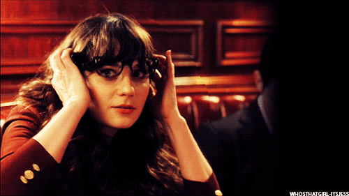 Zooey Deschanel from the TV New Girl is moving her glasses on her face in a 'hubba hubba' 'i am interested in you' fashion