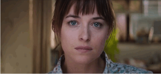 Dakota Johnson as Ana Steele, biting her lip in the beginning of 50 Shades of Grey