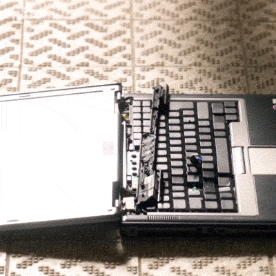 A blonde woman smashing a laptop with a sledgehammer