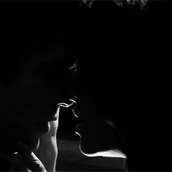 This may contain: the silhouette of two people are shown in black and white, one is holding his hand to his face