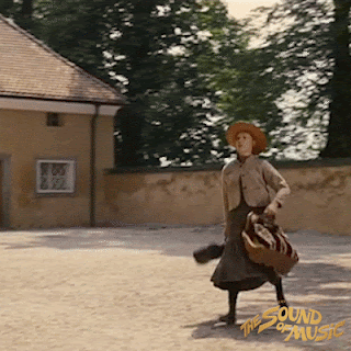 A gif from The Sound of Music. Maria, a young nun, is arriving at her new post with her bags, almost tripping over, but trying to be confident.