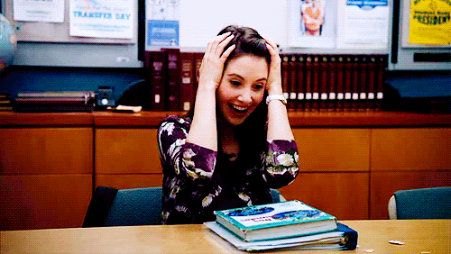 GIF of a woman looking up from a book and smiling