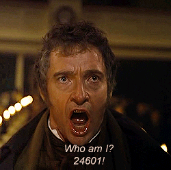 A gif of Hugh Jackman playing Jean Valjean in the film Les Miserables. He is singing, and the caption reads, 'Who am I? 24601.'