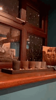 A living room window, with heavy snow falling outside.