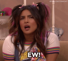 A woman dressed as a teenage girl (pink streaks in her pigtails) is saying, 'Ew' and pulling an exaggerated repulsed face.