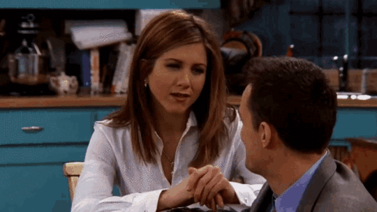 Gif of Rachel Green and Chandler Bing, characters from the TV show Friends. Rachel is a white woman with chest-long dark blonde hair and is shown sitting on a chair, talking. She wears a white blouse, her hands are folded in front of her. Chandler is a white male with short brown hair and is shown obliquely from behind. He is wearing a blue collar shirt under a gray-brown suit jacket. The subtitle reads alternately: That was... and ...surreal. 