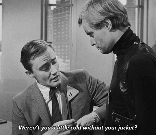A black-and-white gif from The Man from U.N.C.L.E. Napoleon taps a soot-covered Illya on the stomach. "Weren't you a little cold without your jacket?"