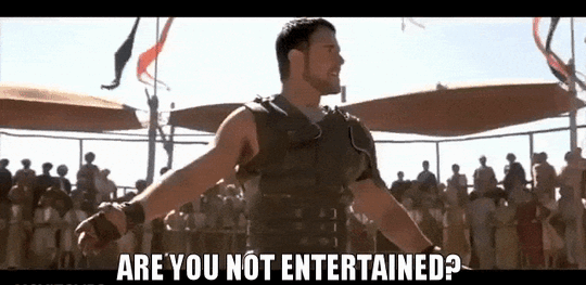 Russell Crowe from Gladiator saying 'Are you not entertained?' to a crowd, then throwing down his sword and spitting on the ground.