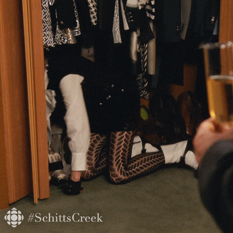 woman hiding in a closet, and closing the folding doors in despair.