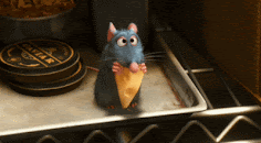 From Rattatouille, a cute animated mouse is nibbling some cheese in a kitchen.