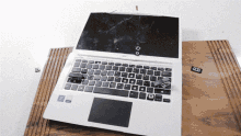 An apple laptop is sitting on a table. It starts to smoke and quickly becomes covered with it.