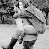 This may contain: a man carrying a woman on his back