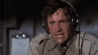 A gif from Airplane - where the character of Ted Striker is flying the plane but is so nervous and scared, sweat is pouring from his face and dripping over his eyes.