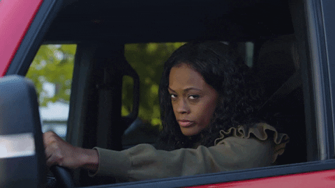 woman glaring while rolling up the car window