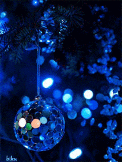 This may contain: an ornament hanging from a christmas tree with blue lights in the back ground