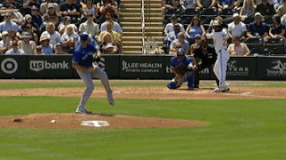 The Blue Jays baseball team are on the pitch, and a bowler is throwing a ball, which the batter misses.