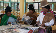 Women reading newspapers in Bolivia. Womankind's partner RED ADA helps boost indigenous and peasant women’s participation in power by building up their skills and abilities.