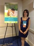 Karen Rock posing by the cover of her upcoming September release, WISH ME TOMORROW